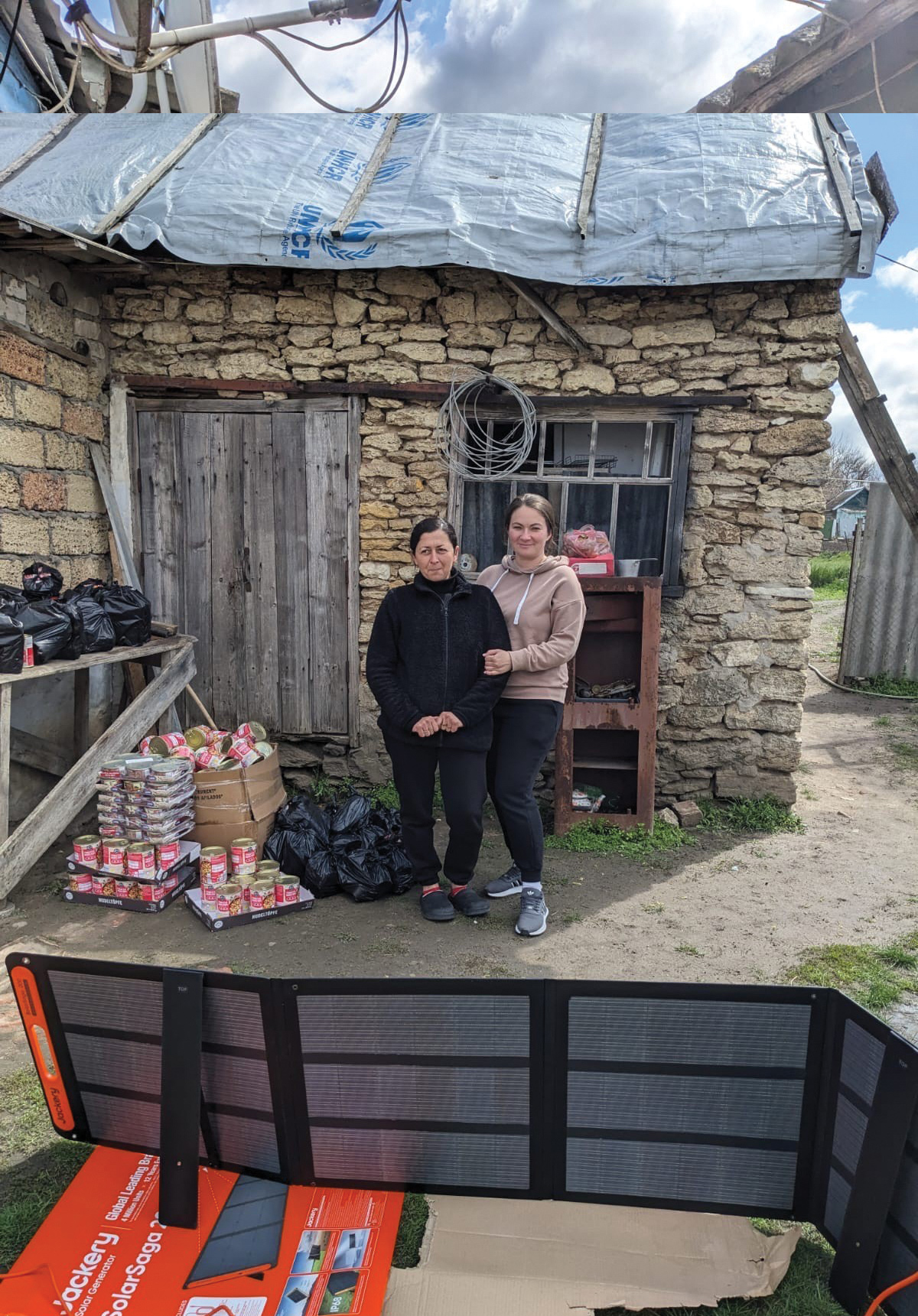 A mother and daughter stand next to the solar panel provided with the Solar Resilience kits.
